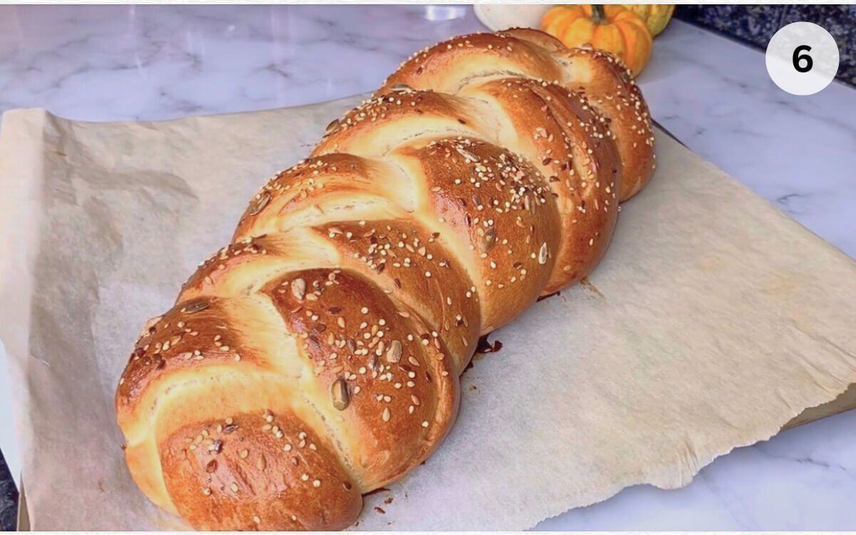 Golden baked challah bread sliced showing soft fluffy interior texture.