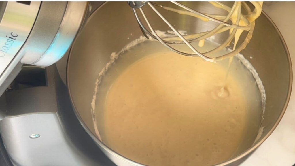 Uncooked apple cake batter in a mixing bowl, ready to be poured into a baking pan.