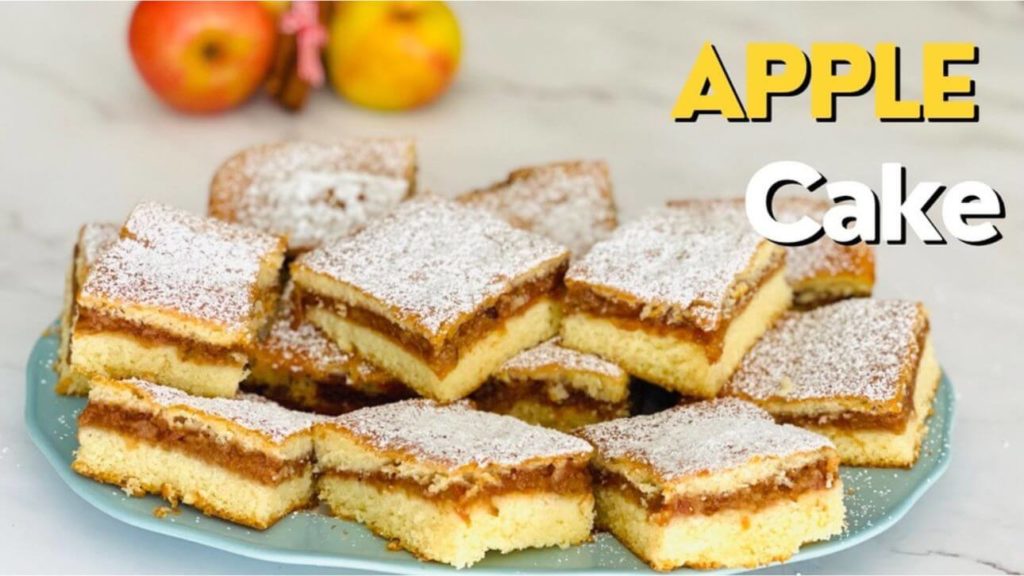 Delicious homemade apple cake with a golden crust, slices of fresh apples, and a dusting of powdered sugar on top.