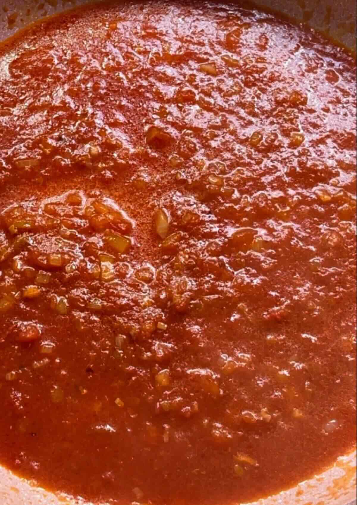 Pan with tomato sauce, a flavorful base for Chickpea Ratatouille, a Mediterranean-inspired dish rich in tomatoes and vegetables.