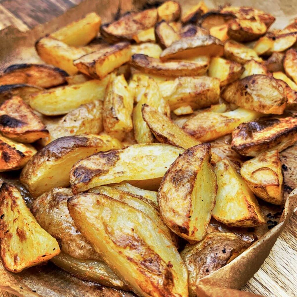 Golden brown and crispy baked potatoes on an oven tray