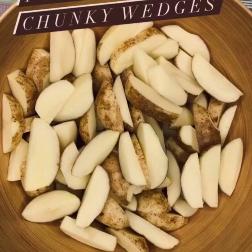 Wedges of potatoes arranged in a rustic brown bowl.