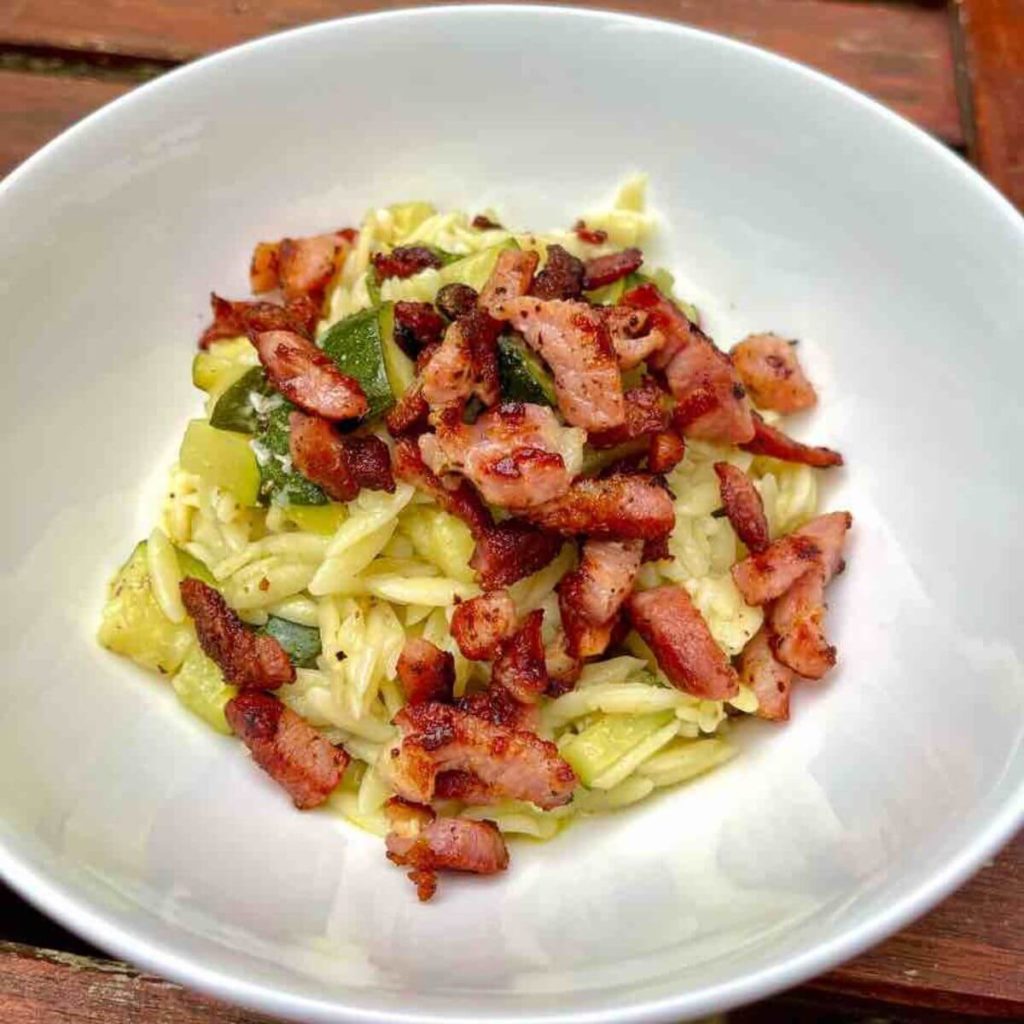 Savory Pancetta and Zucchini Pasta in a white bowl.