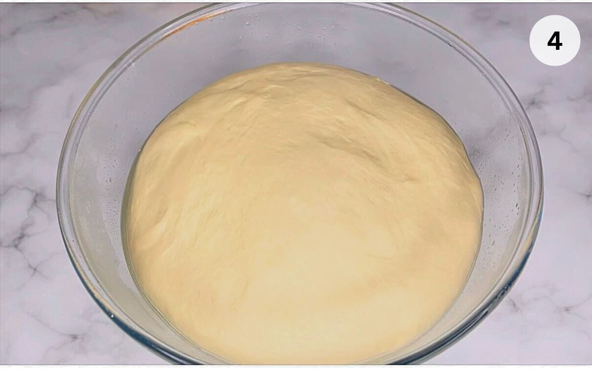 Simple 3-strand challah bread dough rising in a bowl for a lazy day breakfast.