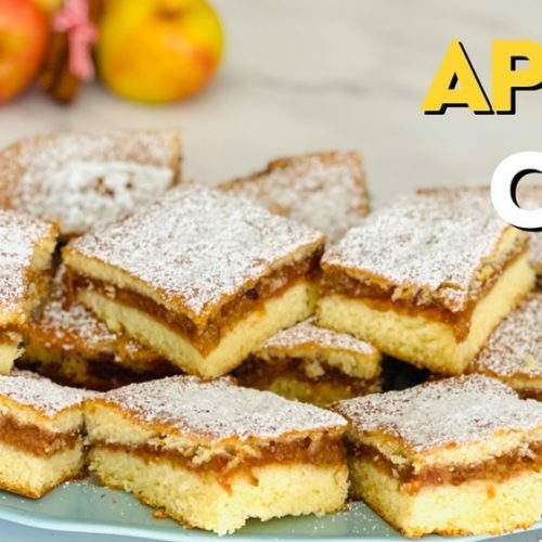 Delicious homemade apple cake with a golden crust, slices of fresh apples, and a dusting of powdered sugar on top.