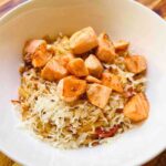 Tomato orzo with grilled salmon served in a bowl