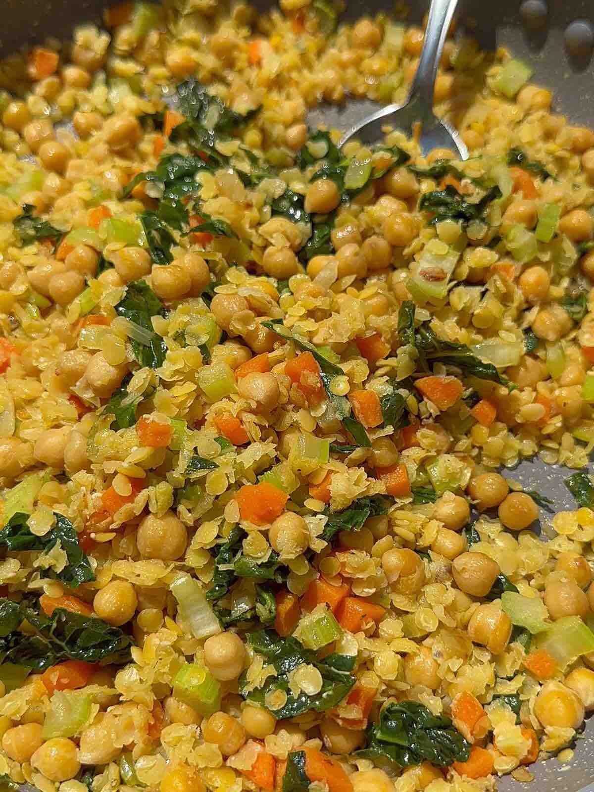 Vegetarian Mediterranean Bowl: A plate filled with sautéed onions, diced celery, cubed carrots, chopped garlic, chickpeas, kale, cooked lentils, and a hint of cumin, seasoned with salt and pepper. Served with a dollop of Greek yogurt or kefir for a creamy finish.