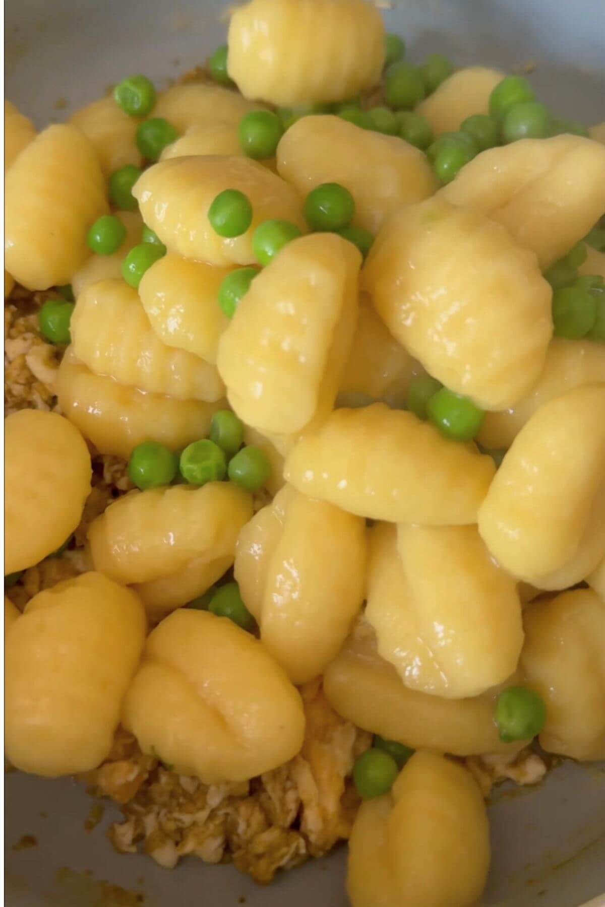 Cooked gnocchi and peas added to the pan with crumbled omelette and pesto