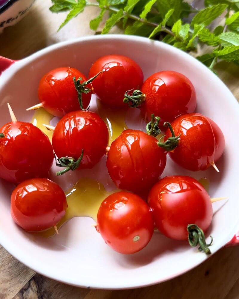 Fresh cherry tomatoes drizzled with olive oil, ready to grill for Smashed Kefta Tacos.