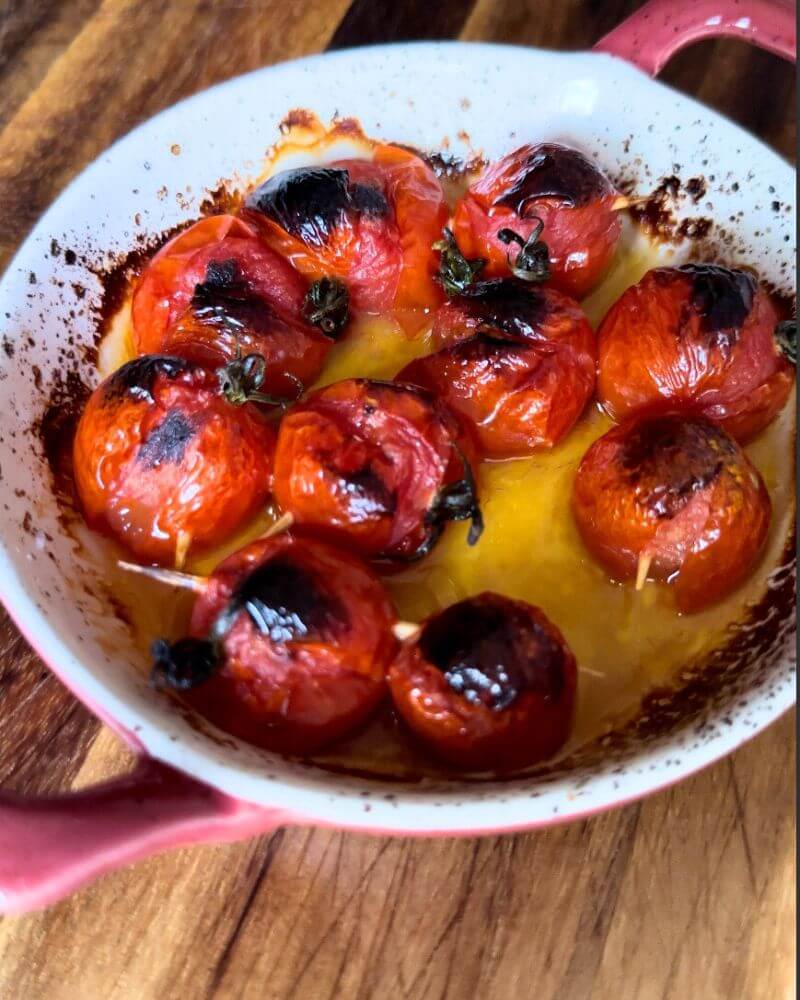 Juicy cherry tomatoes drizzled with olive oil, roasting in the oven for Smashed Kefta Tacos.