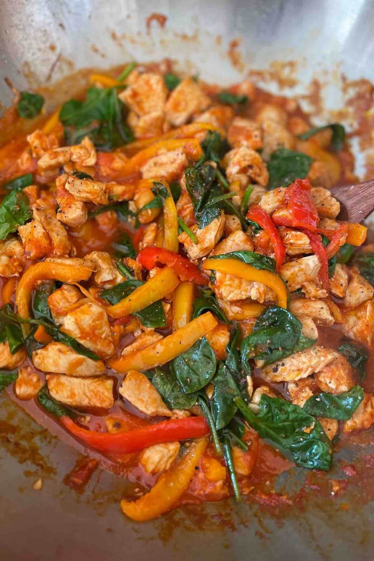 Creamy spinach and pepper chicken in a pan. 