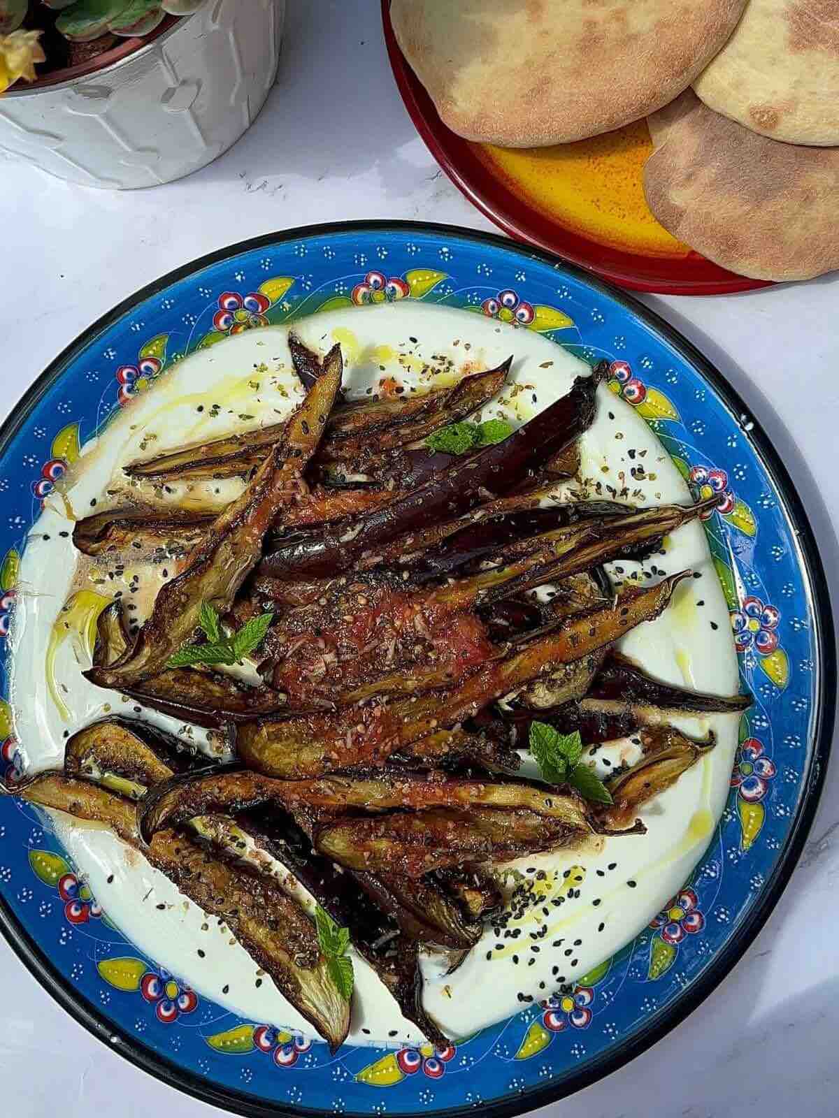 Grilled eggplant atop a base of creamy yogurt sauce