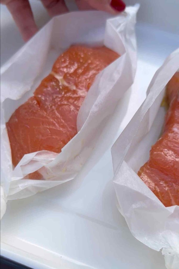 marinated salmon placed in parchment paper to be oven baked