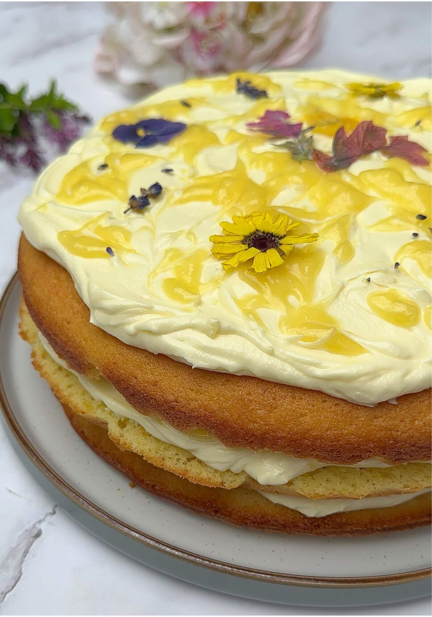 Lemon cake with lemon cream cheese frosting, lemon curd, and edible flowers.