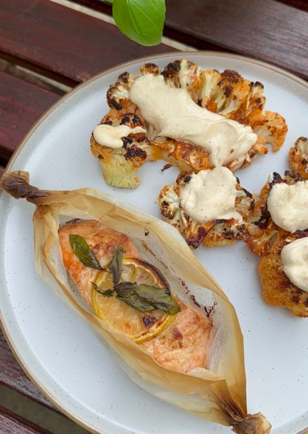 Salmon en Papillote served with cauliflower steaks topped with tahini sauce.