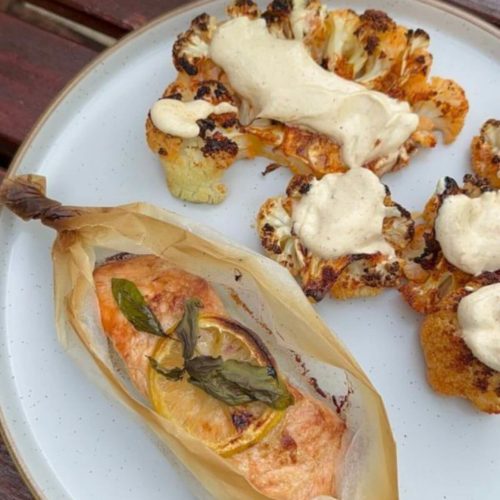 Salmon en Papillote with a side of roasted cauliflower drizzled in tahini sauce.