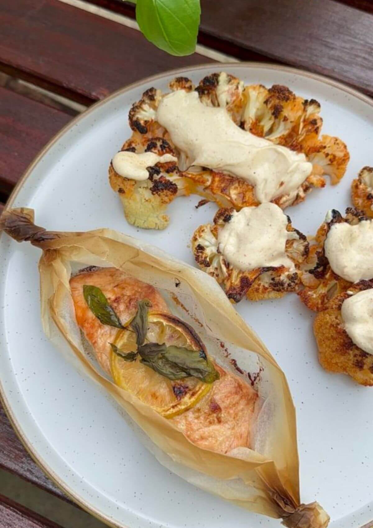 Salmon en Papillote with a side of roasted cauliflower drizzled in tahini sauce.