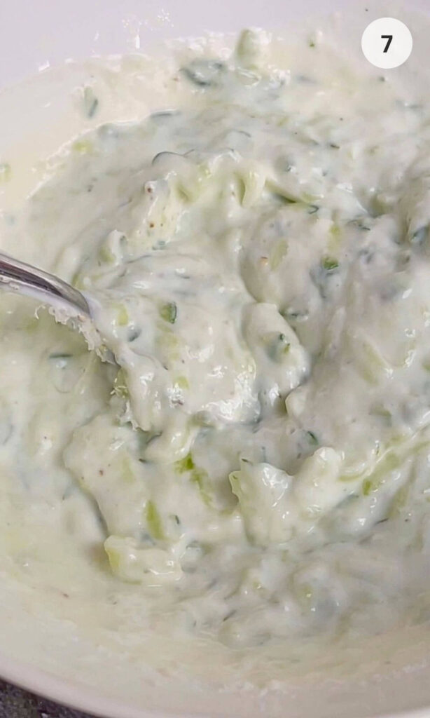 Creamy homemade tzatziki sauce in a white bowl.