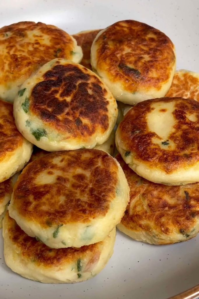 Golden-browned potato cakes layered onto a plate. 