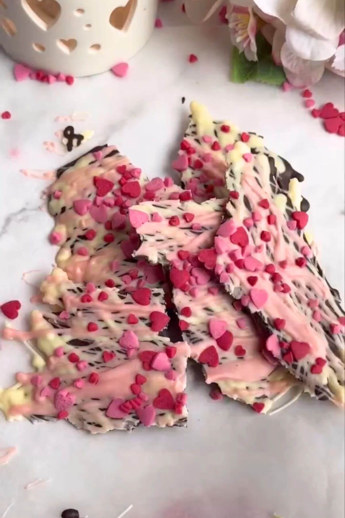 Chocolate bark made with dark, white and pink chocolate, decorated with heart shaped sprinkles.