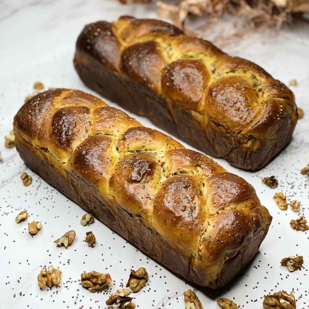 Two baked golden-brown walnut rolls.