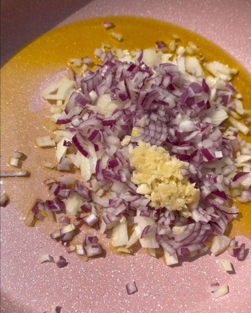 Olive oil, chopped red onion, grated garlic in a pan to make borek. 