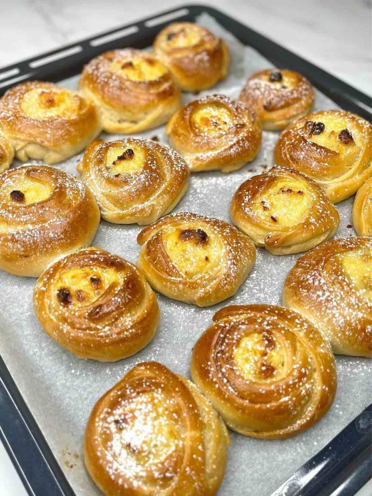 Tray of rose-shaped mini ricotta cakes topped with vanilla powdered sugar