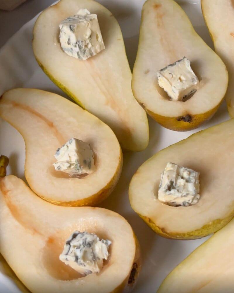 Gorgonzola cheese cubes placed into pear halves. 