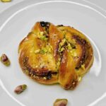 Soft pistachio babka buns with glaze and chopped nuts.