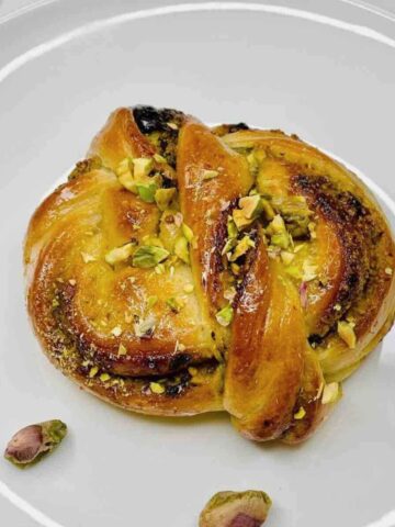 Soft pistachio babka buns with glaze and chopped nuts.