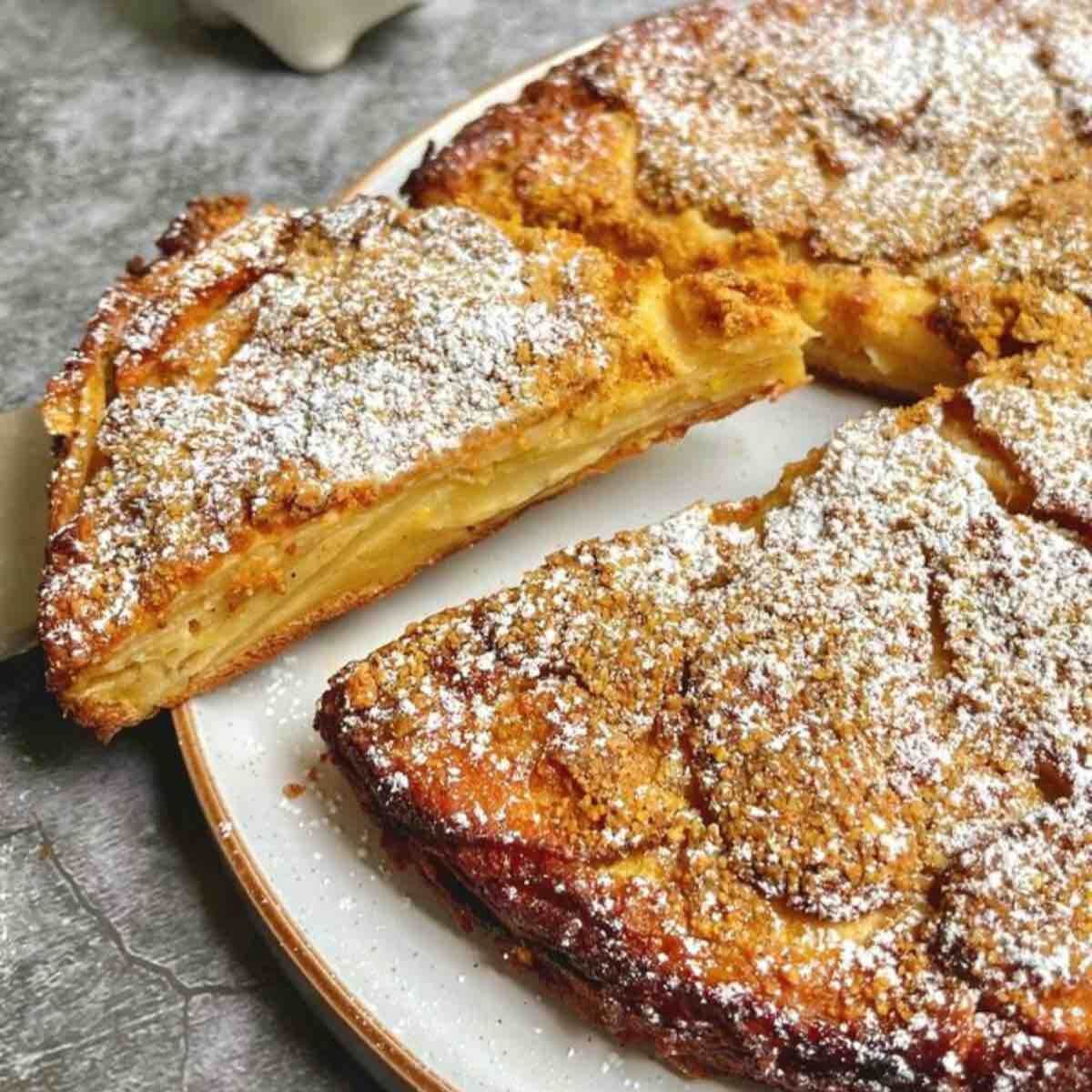 Close-up of a rustic apple cake slice, so full of tender apples that the batter is barely visible.
