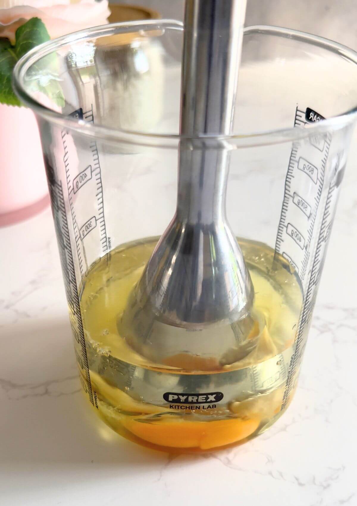 Immersion blender mixing sunflower oil, egg, mustard, lemon juice, and salt in a glass jar to make 4-ingredient mayo. 