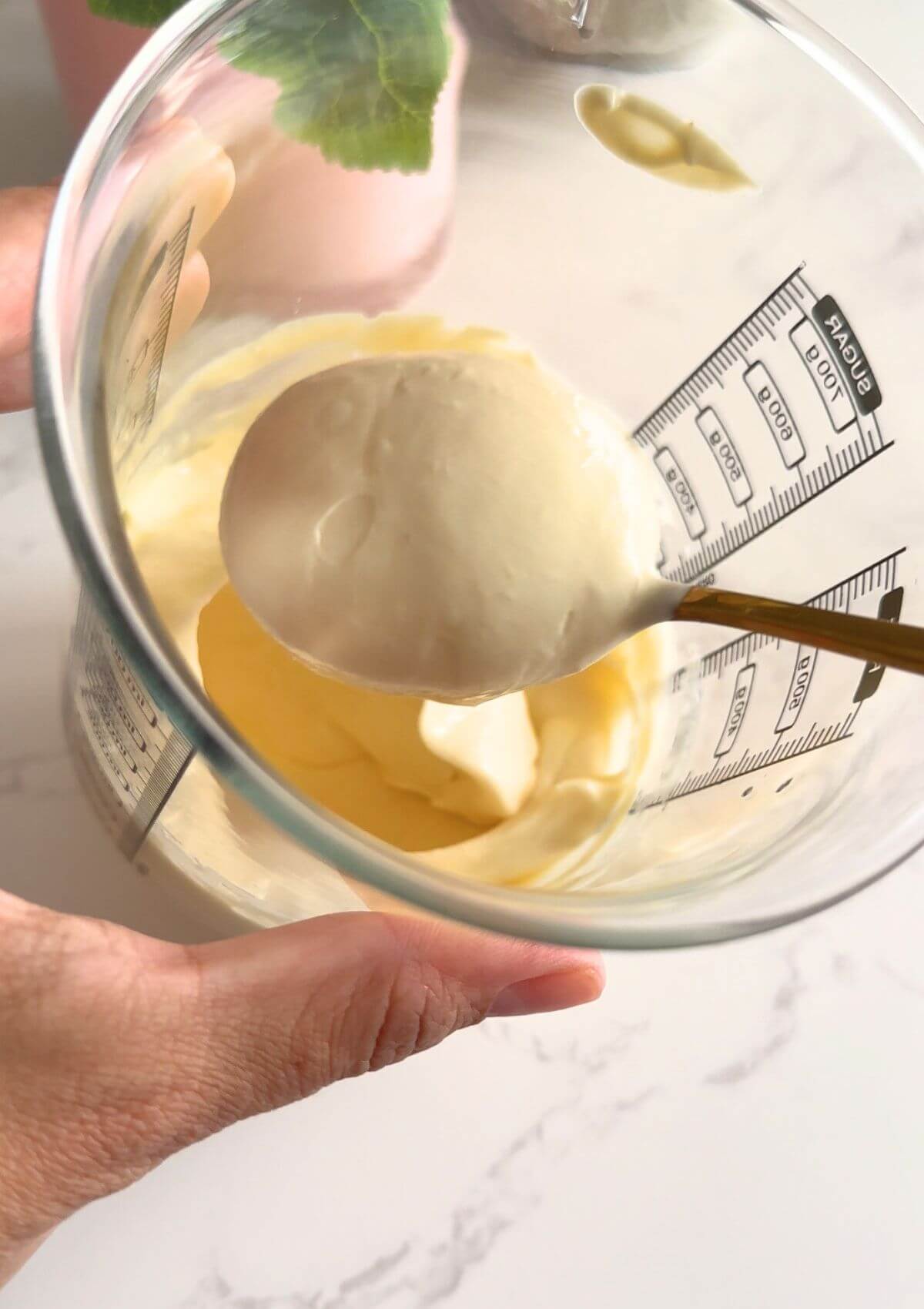 Creamy 4-ingredient mayo in a jar, with a spoon lifting to show its smooth, emulsified texture.
