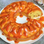 Apple and Raisin Bundt Cake with Caramel Sauce with a slice taken out so you can see the inside of the cake