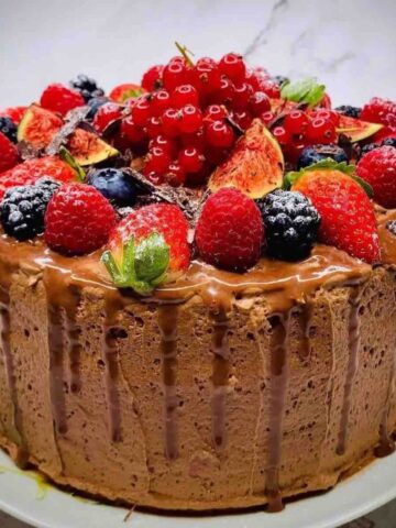 Moist Rich Chocolate Three Layer Berry Mousse Cake decorated with fresh fruits.