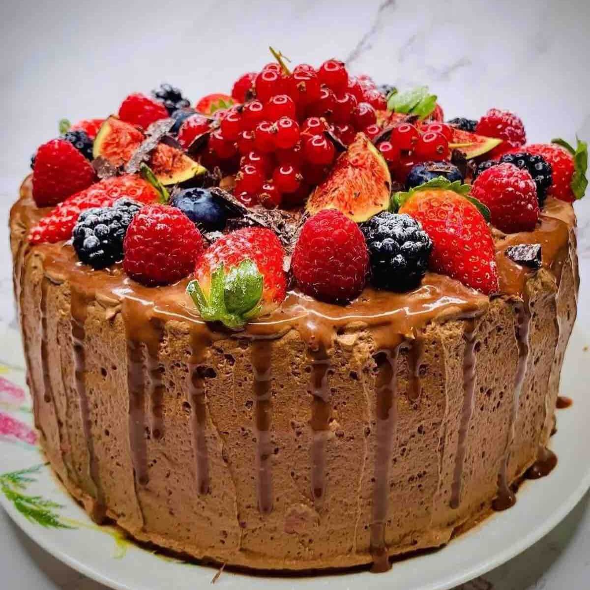 Moist Rich Chocolate Three Layer Berry Mousse Cake decorated with fresh fruits.