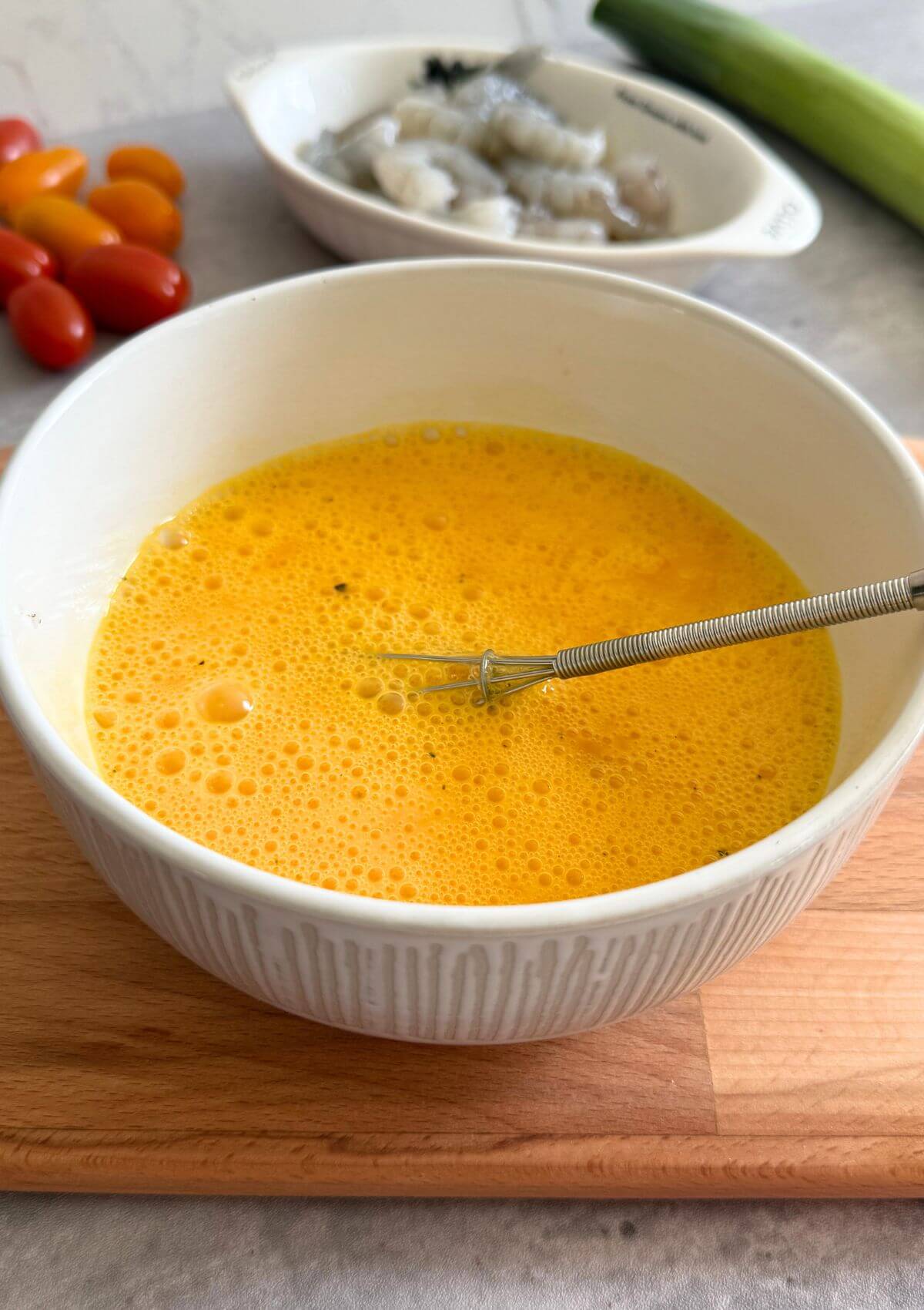 Whisking eggs until fluffy for light, airy texture.