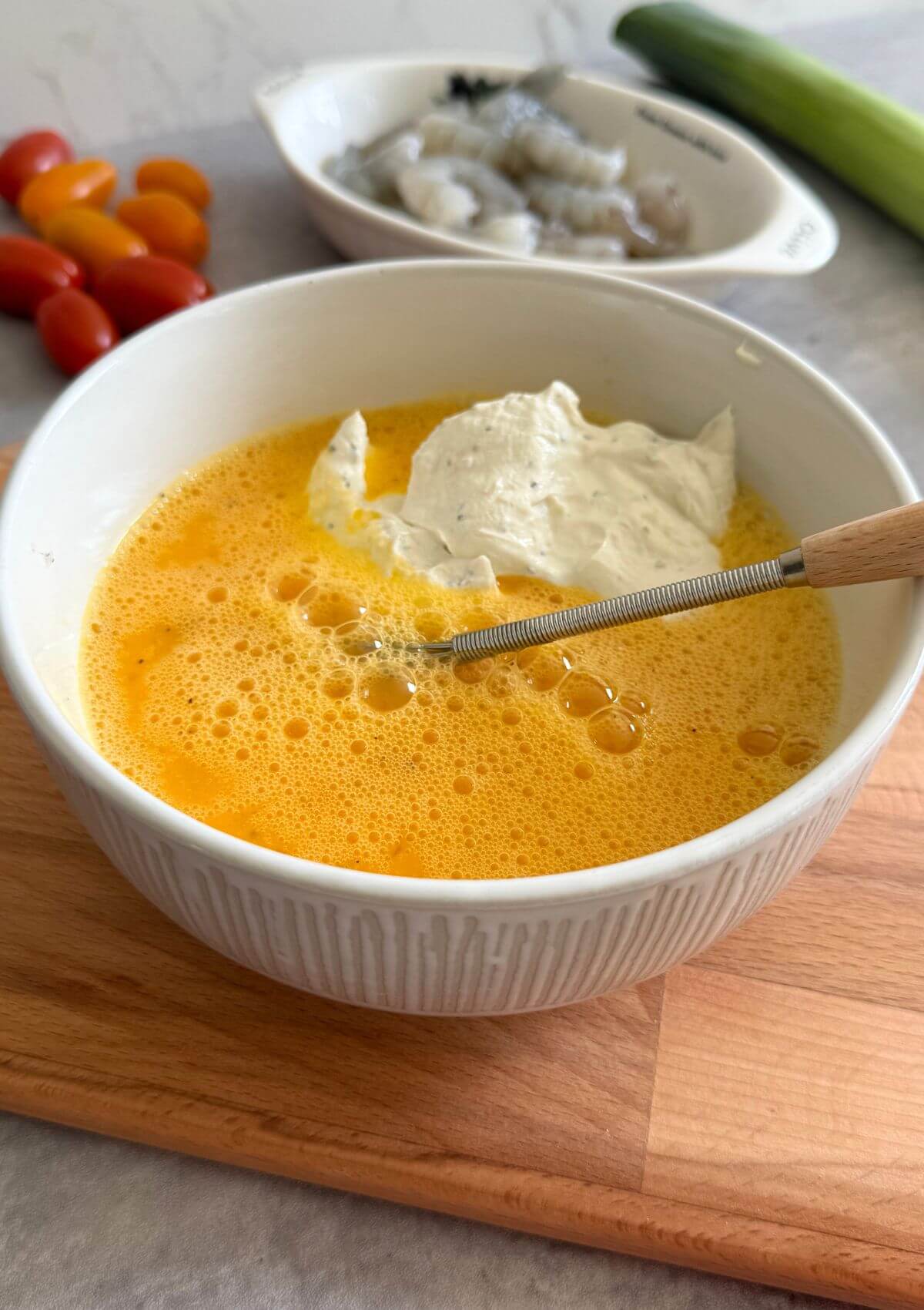 Adding cream cheese lumps to eggs for creamy pockets.