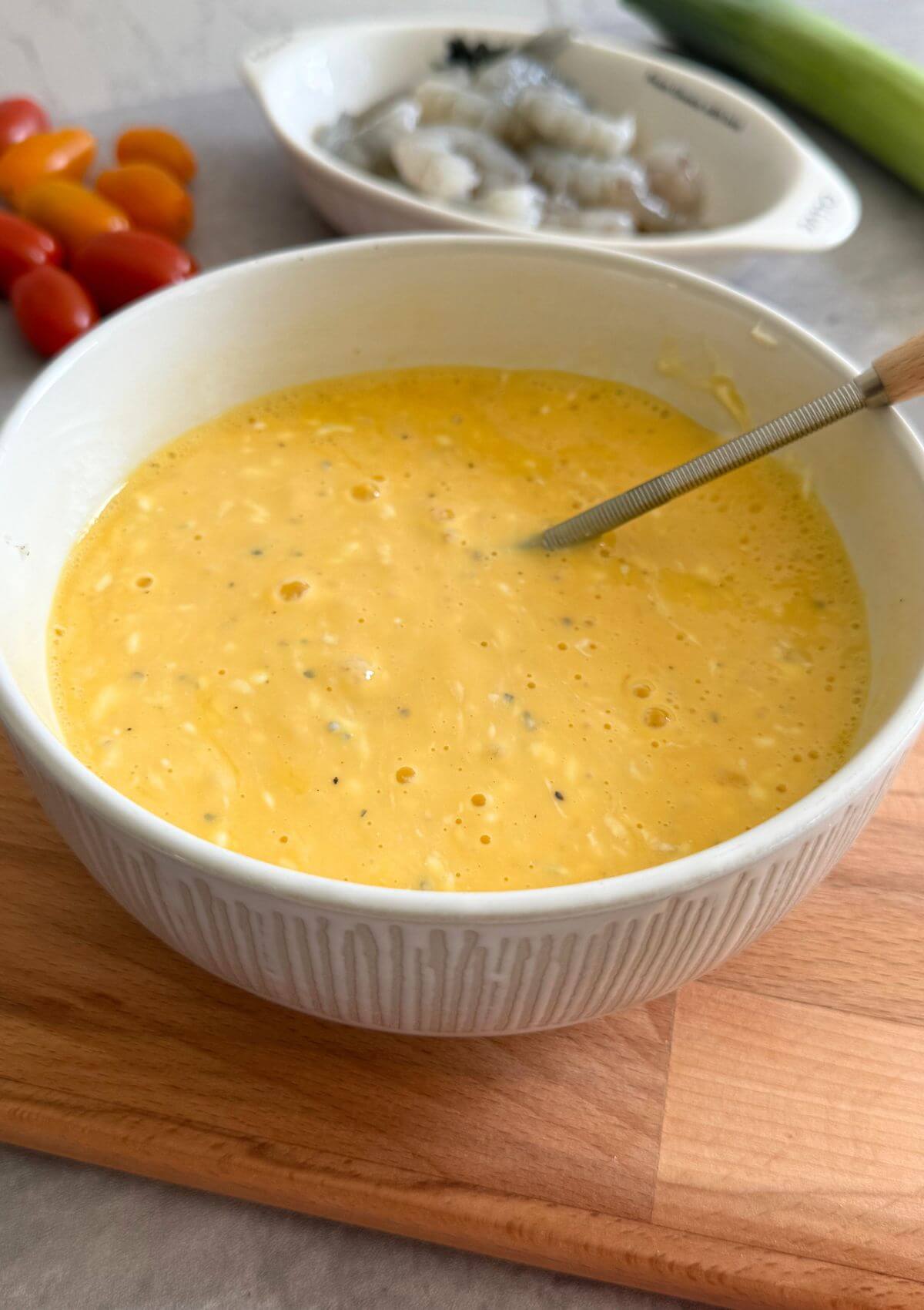 Gently mixing eggs and cheese with streaks visible.