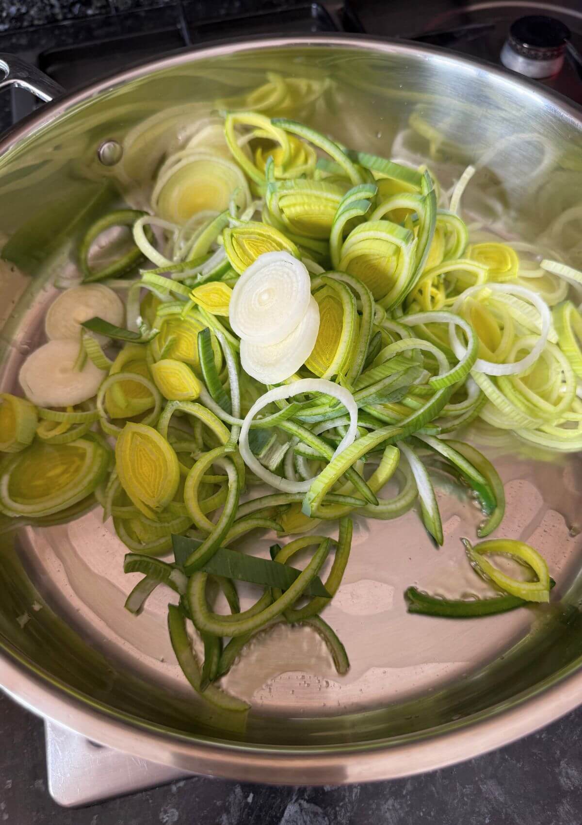 Sliced leeks sautéing until soft in olive oil.