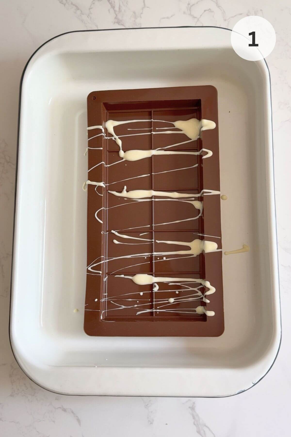 White chocolate drizzled into the mould, ready for freezing.
