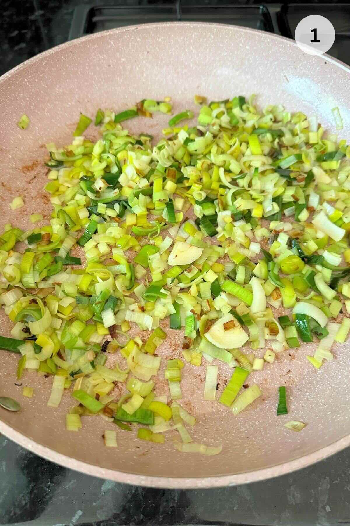 Leeks sizzling in a hot wok, turning fragrant and golden.
