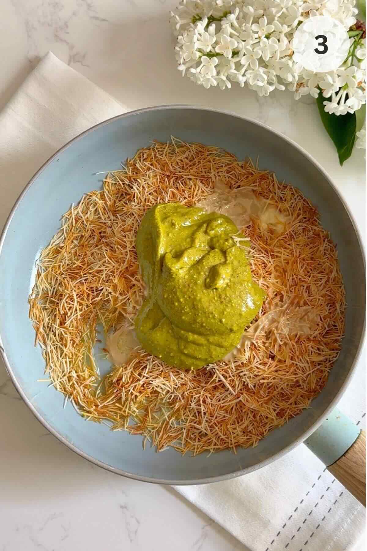 Melted butter, kataifi, pistachio butter, and tahini in a skillet.