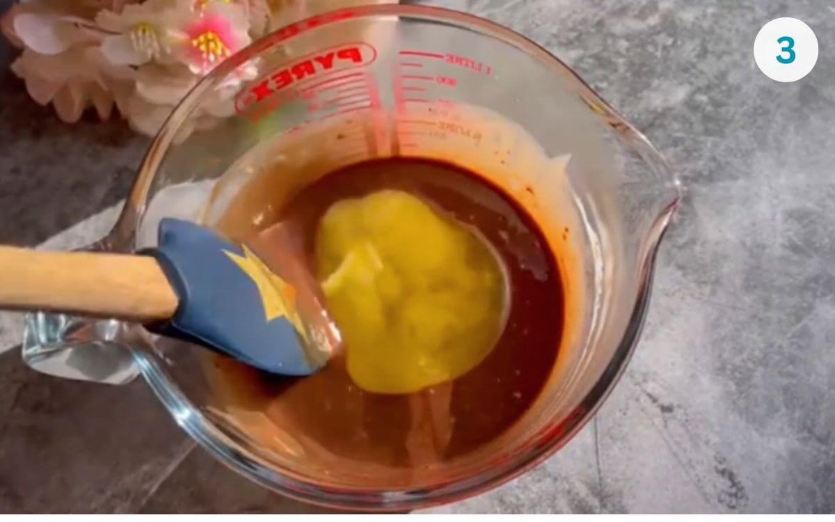 Melted butter poured into the bowl of cream and Nutella, ready to be stirred into ganache.