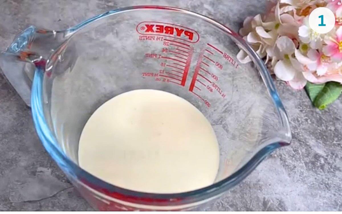 Whipping cream poured into a microwave-safe glass bowl.