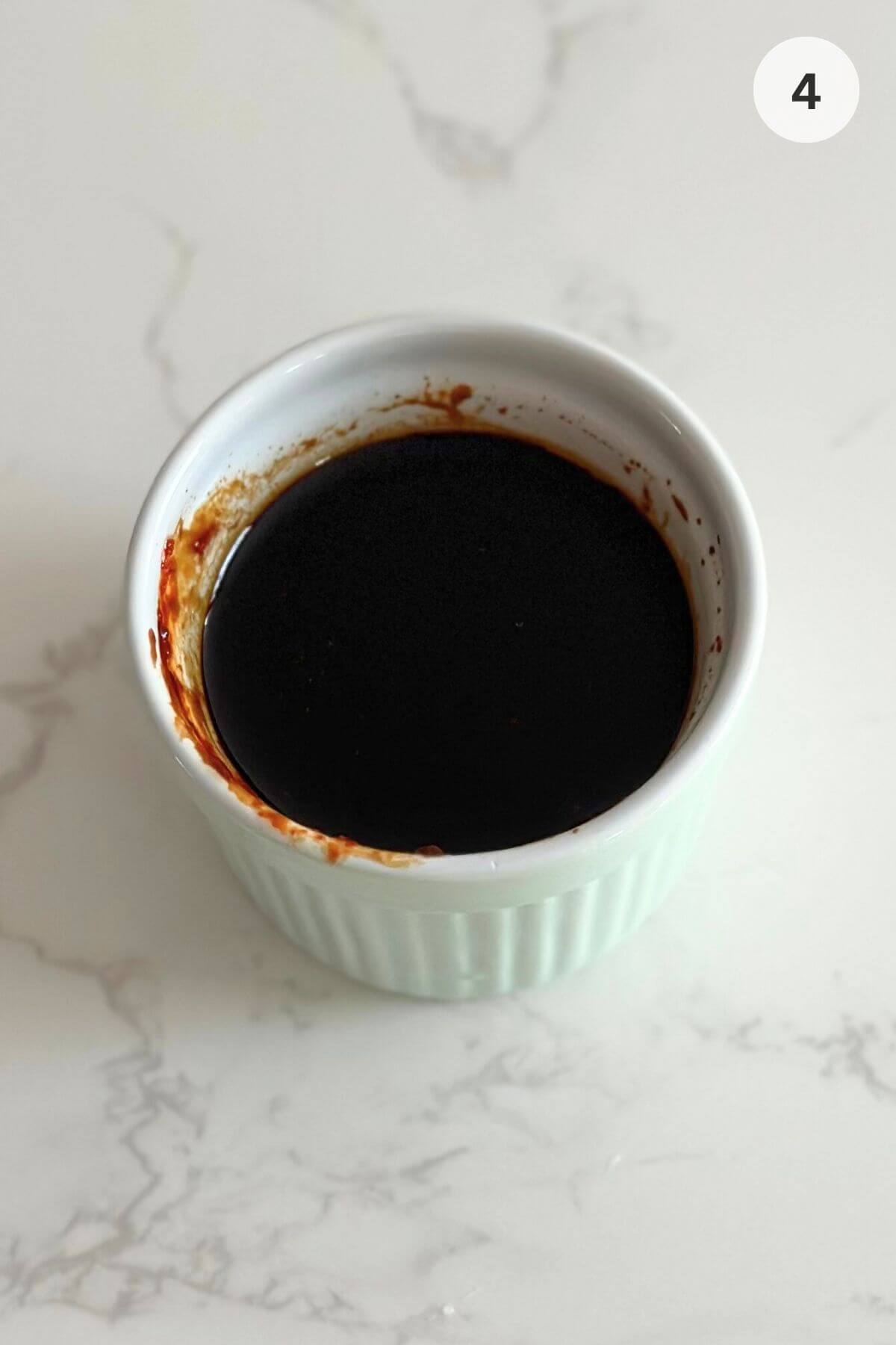 Whisking dark soy, oyster sauce, and gochujang in bowl. 