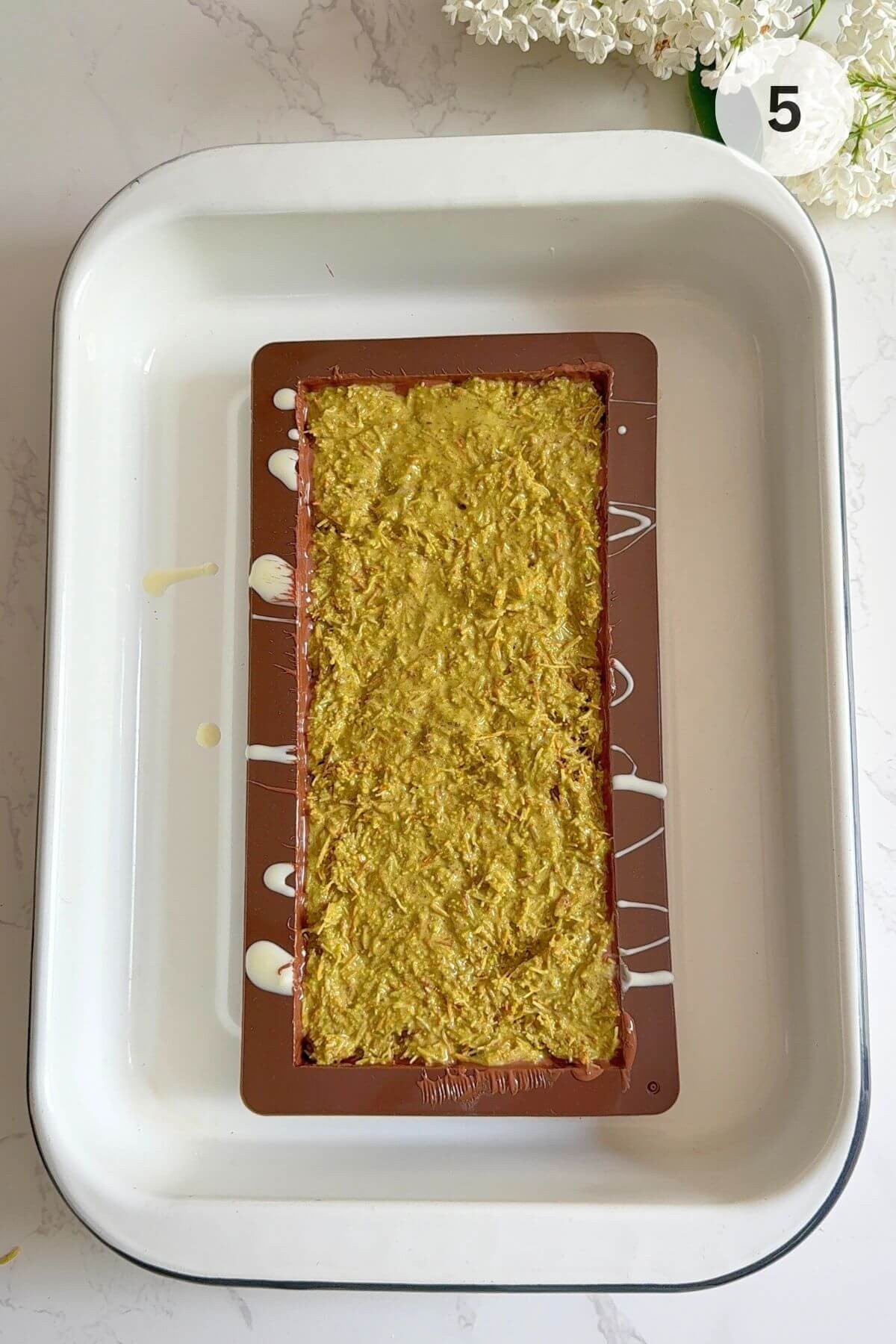 Pistachio kataifi filling pressed into the mould, evenly spread.