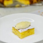 Alivenci slice on a plate topped with sour cream and powdered sugar.