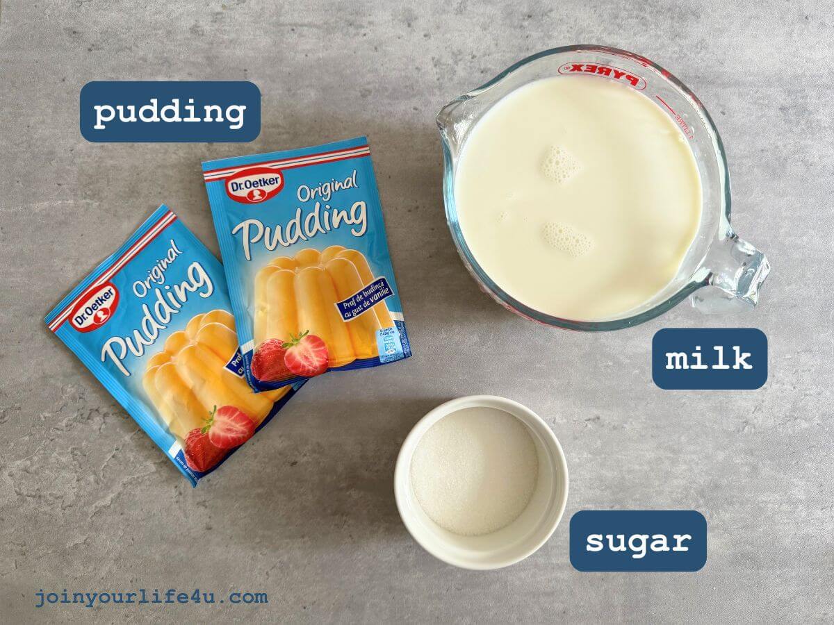 Vanilla pudding, milk, sugar individually displayed on a table. 