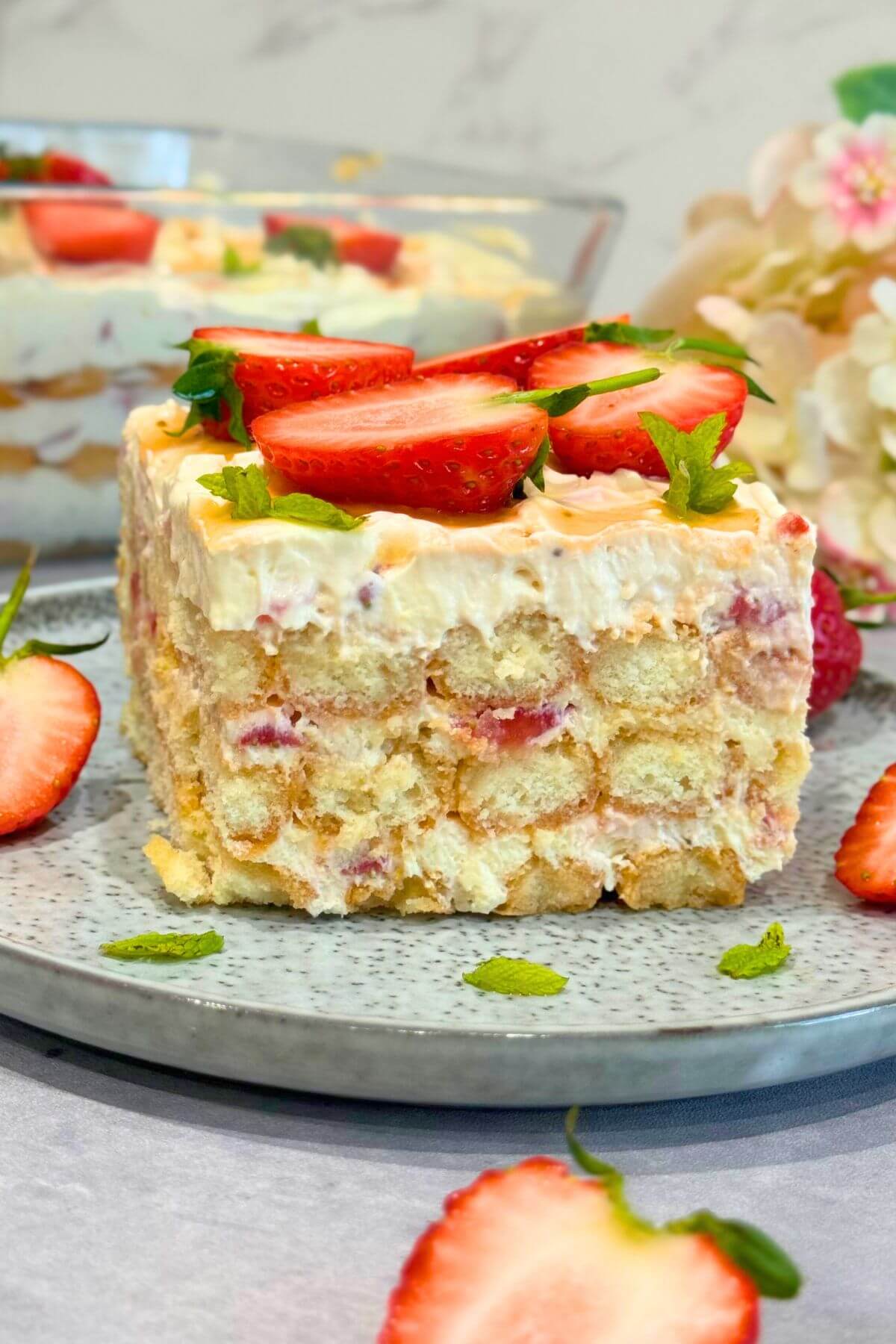 Square of no-bake strawberry tiramisu on a plate, showing its creamy and layered texture